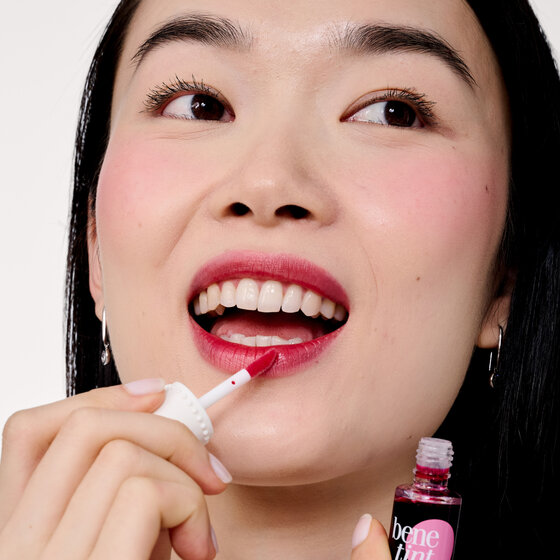 Model applying Benetint to lips